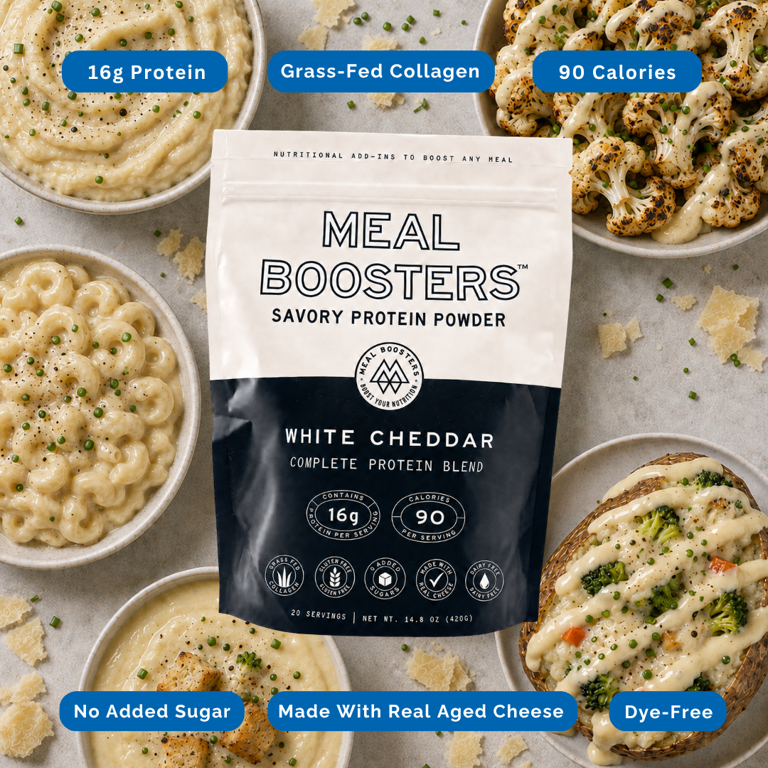 A stand-up pouch of Meal Boosters Savory Protein Powder in White Cheddar flavor is centered on a styled flat-lay of cheese dishes. Blue callout badges around the product read 16g Protein, Grass-Fed Collagen, 90 Calories, No Added Sugar, Made With Real Aged Cheese, and Dye-Free.