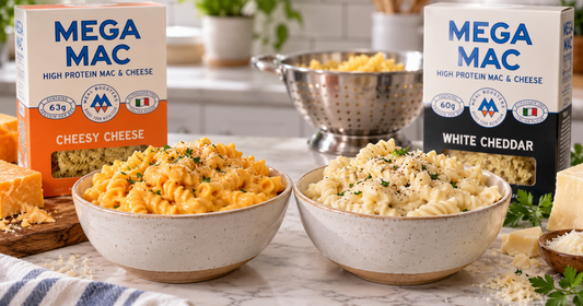 Prepared Mega Mac mac and cheese served in bowls, with the Cheesy Cheese and White Cheddar boxes behind them